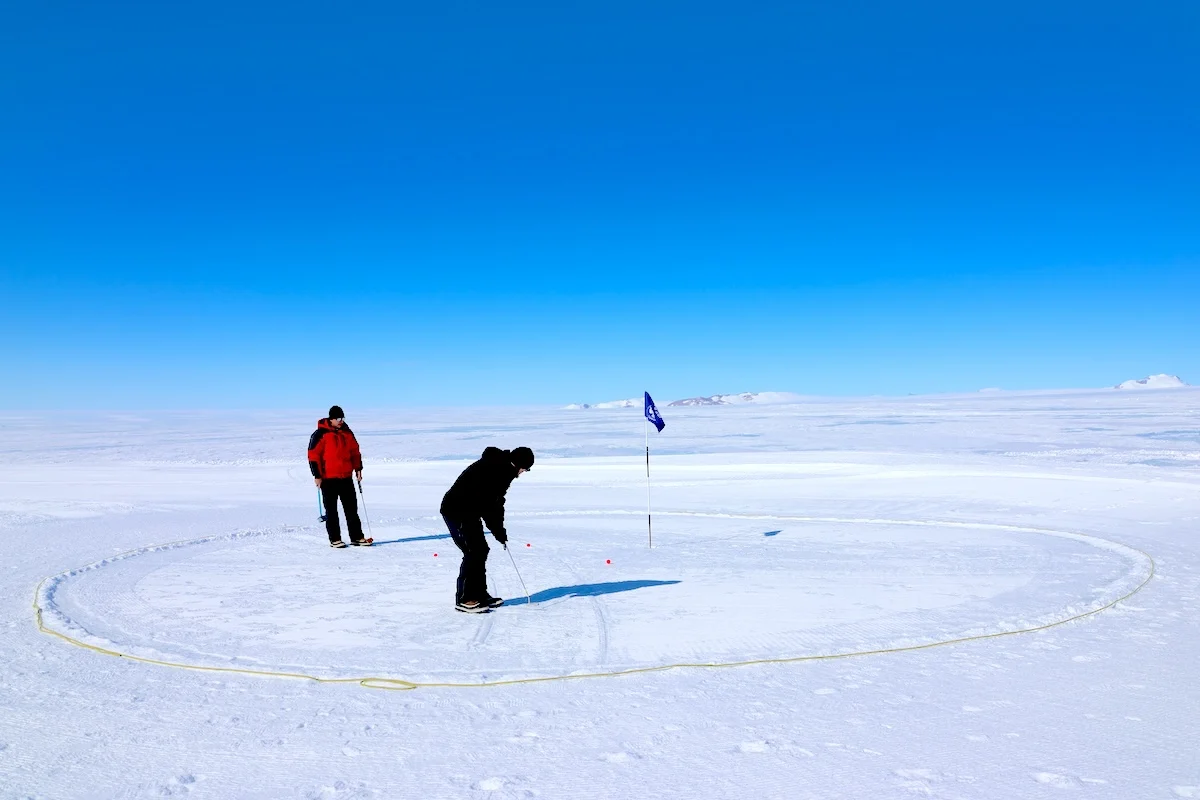 Golfers playing on an Antarctic snow course