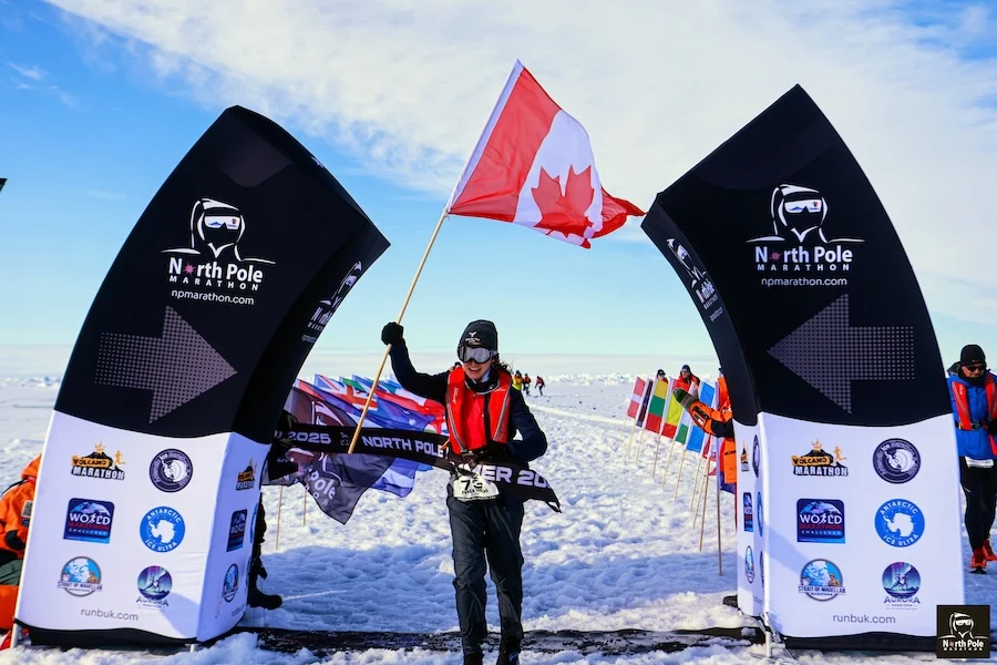 North Pole Marathon finisher beneath the race arch